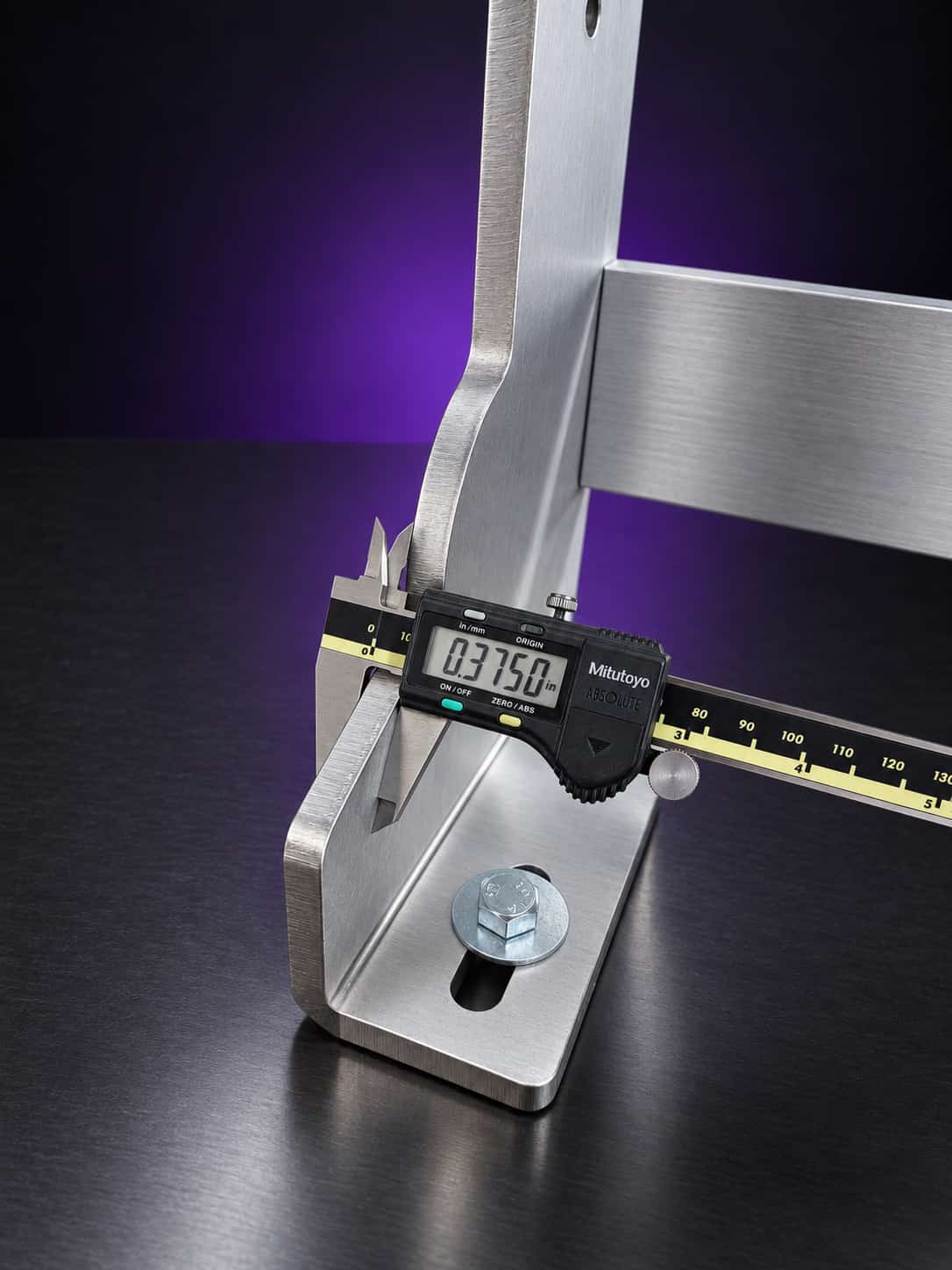 Calipers reading 0.375 inch across a chassis leg plate above its slotted foot and bolt, on black with a purple glow