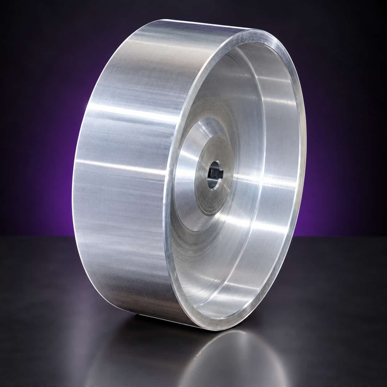 Polished aluminum drive wheel with keyed bore, three-quarter view of the dished face, on black with a purple glow