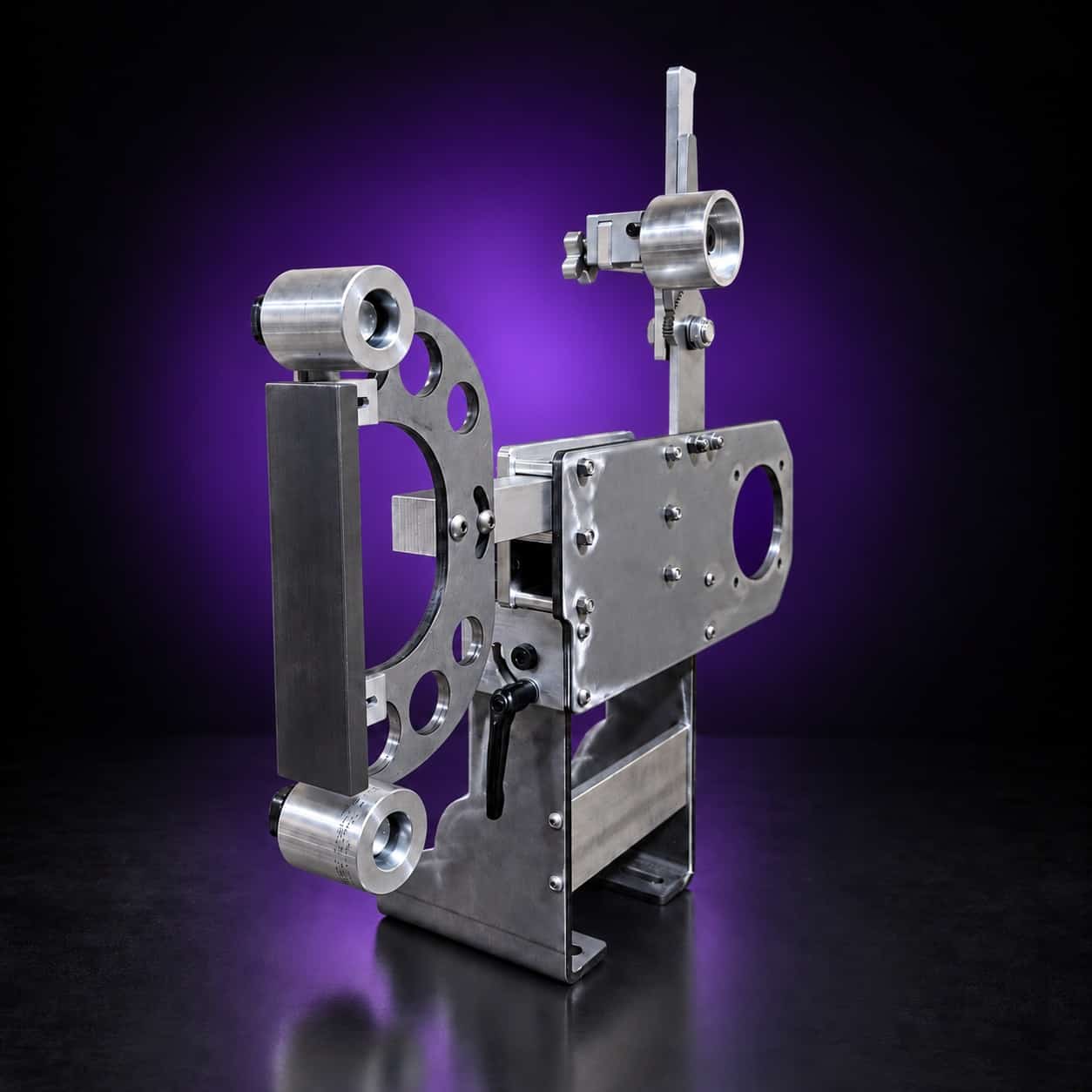 Torus steel 2x72 grinder from the platen side, wide three-quarter view with legs and feet, on black with a purple glow