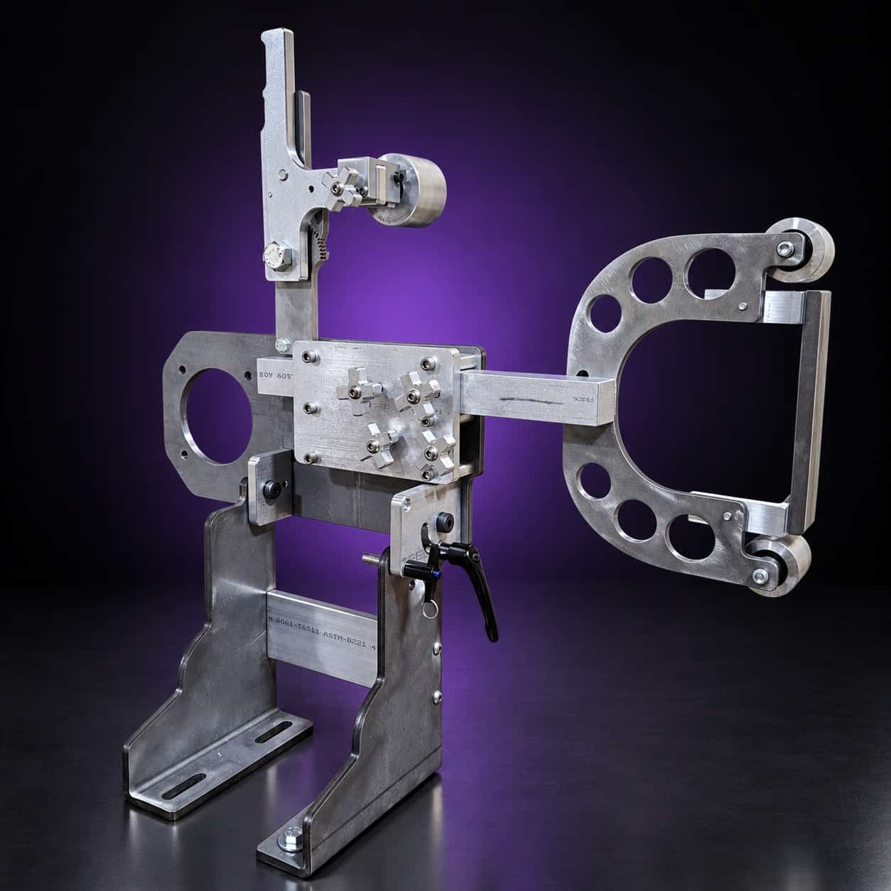 Torus steel 2x72 grinder, front three-quarter view: arm out to the right, star knobs, T-handle, on black with a purple glow