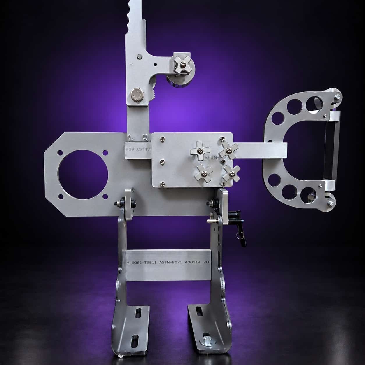 Torus steel 2x72 grinder, straight front view: motor plate left, four star knobs, arm right, on black with a purple glow