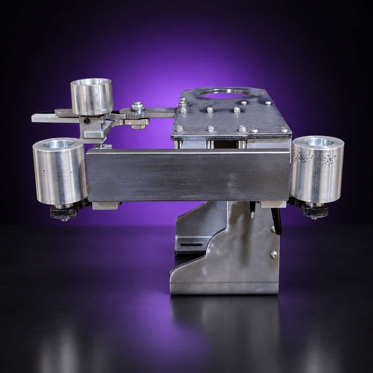 Torus steel 2x72 grinder laid horizontal, front view: flat bar with an idler wheel at each end, on black with a purple glow