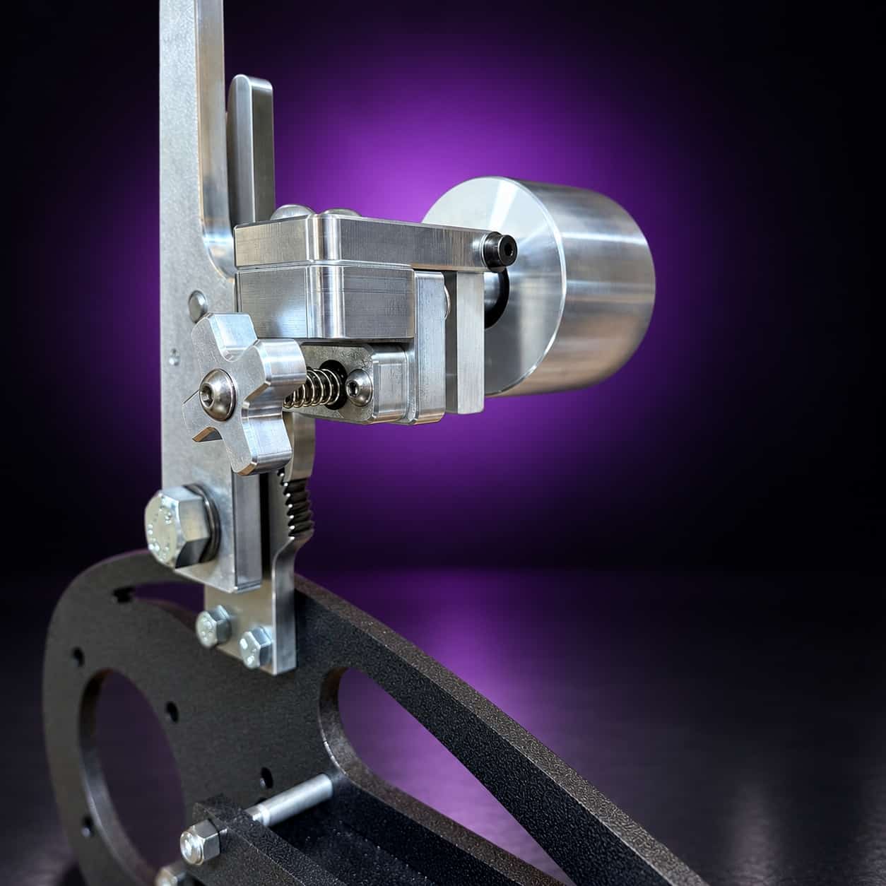 Nebula dual-axis tracking assembly: star knob, spring and idler wheel, close-up, on black with a purple glow
