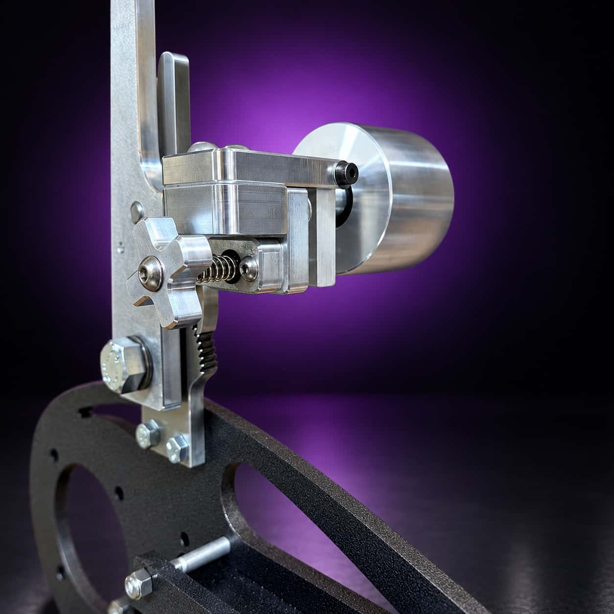 Nebula dual-axis tracking assembly: star knob, spring and idler wheel, close-up, on black with a purple glow