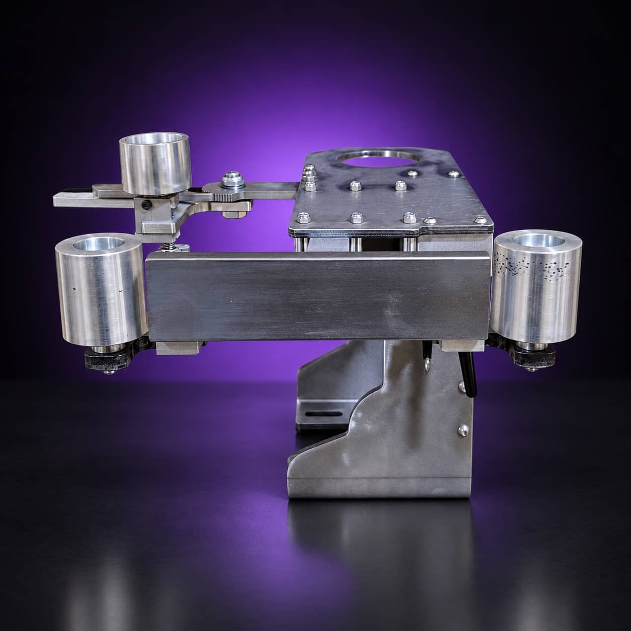 Torus steel 2x72 grinder laid horizontal, front view: flat bar with an idler wheel at each end, on black with a purple glow