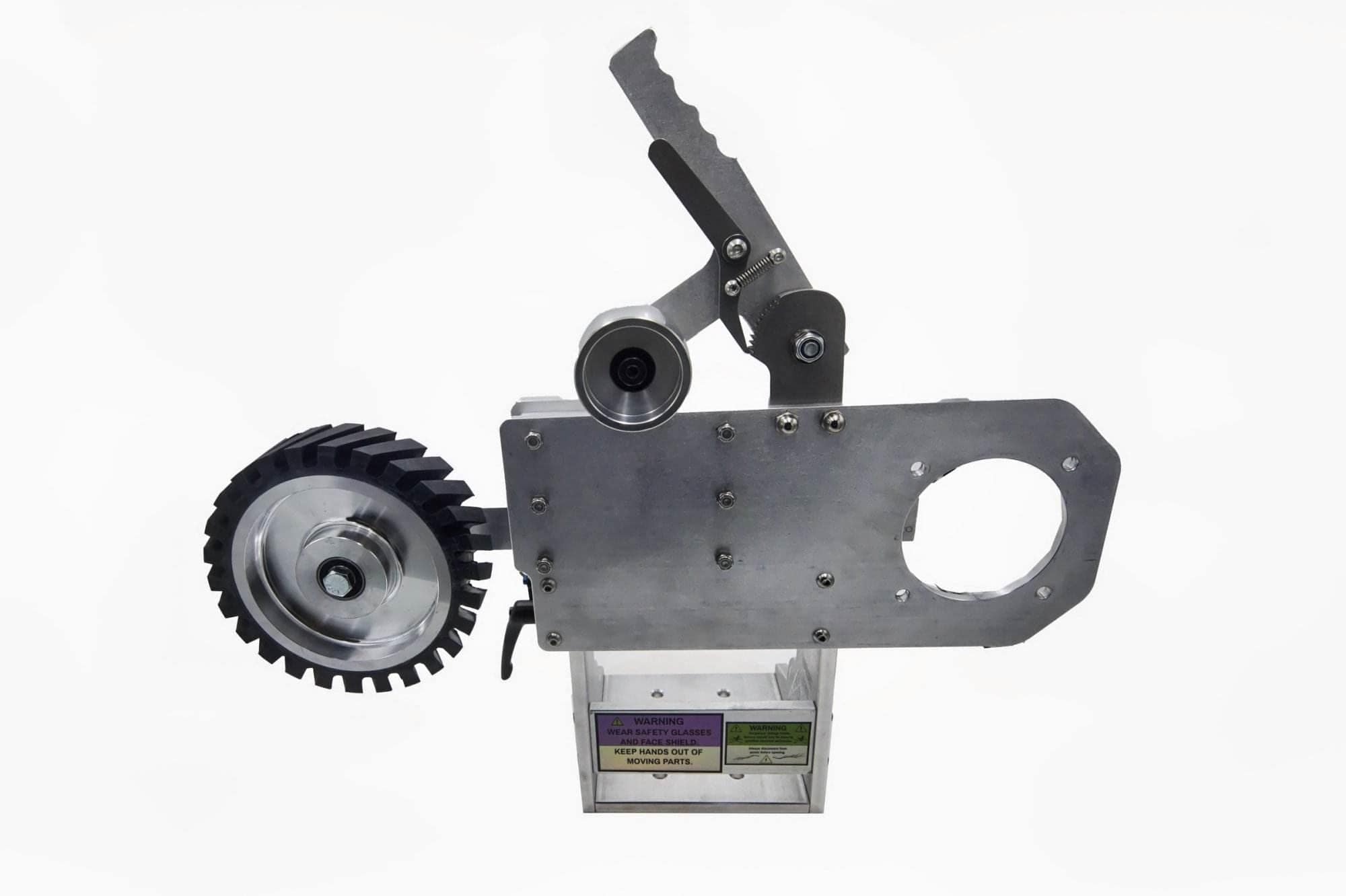 Toothed rubber drive wheel mounted on a Torus CNC 2x72 grinder tooling arm with warning stickers