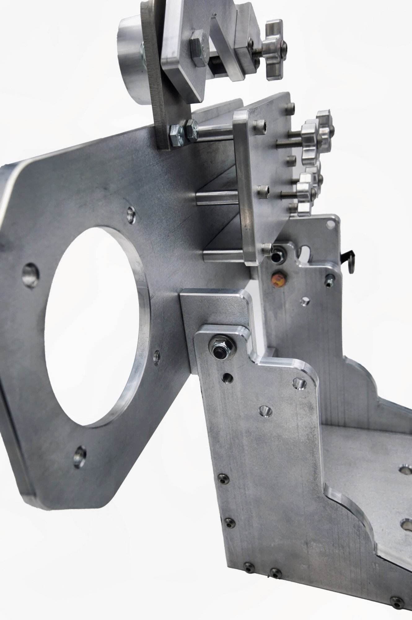 Angled view of a mounting plate's cross-knob adjusters and hook-style locking lever on an arm