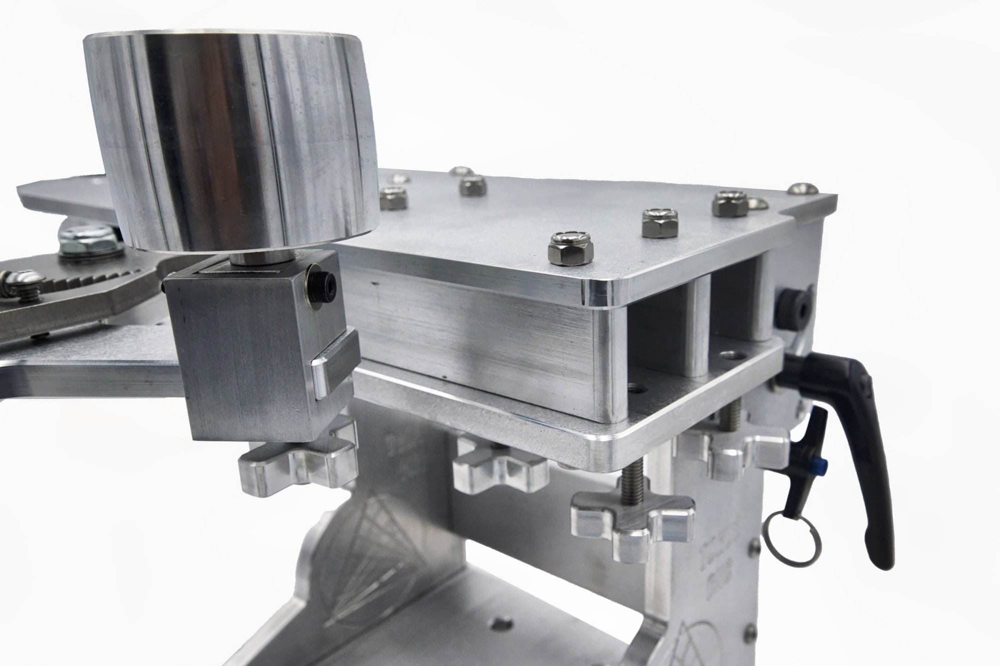 Close-up of hex nuts and cross-knob adjusters securing a wheel mount on a grinder tooling arm