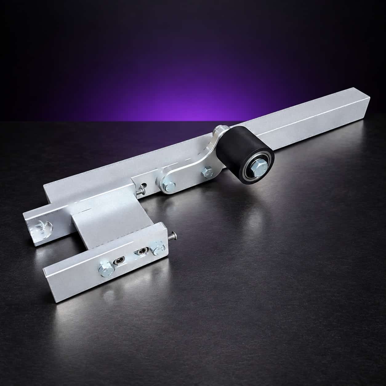 Small wheel attachment arm with holder and black rubber idler roller, no wheels, angled view, on black with a purple glow