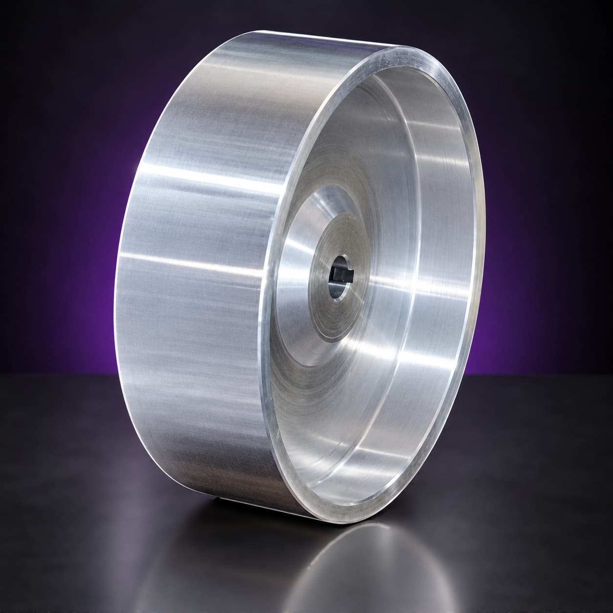 Polished aluminum drive wheel with keyed bore, three-quarter view of the dished face, on black with a purple glow
