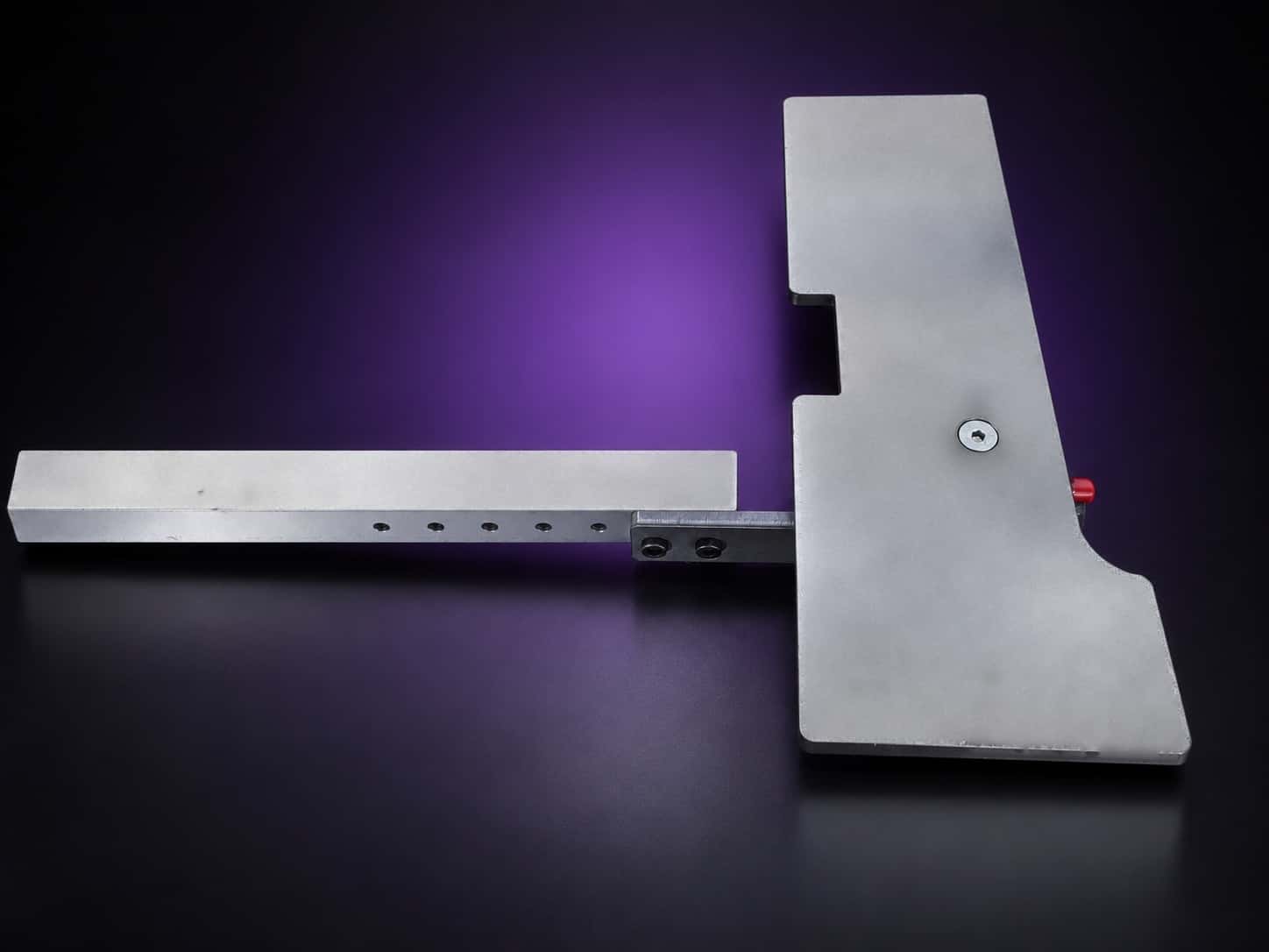 Steel work table plate on its drilled square aluminum arm bar, seen from above, on black with a purple glow