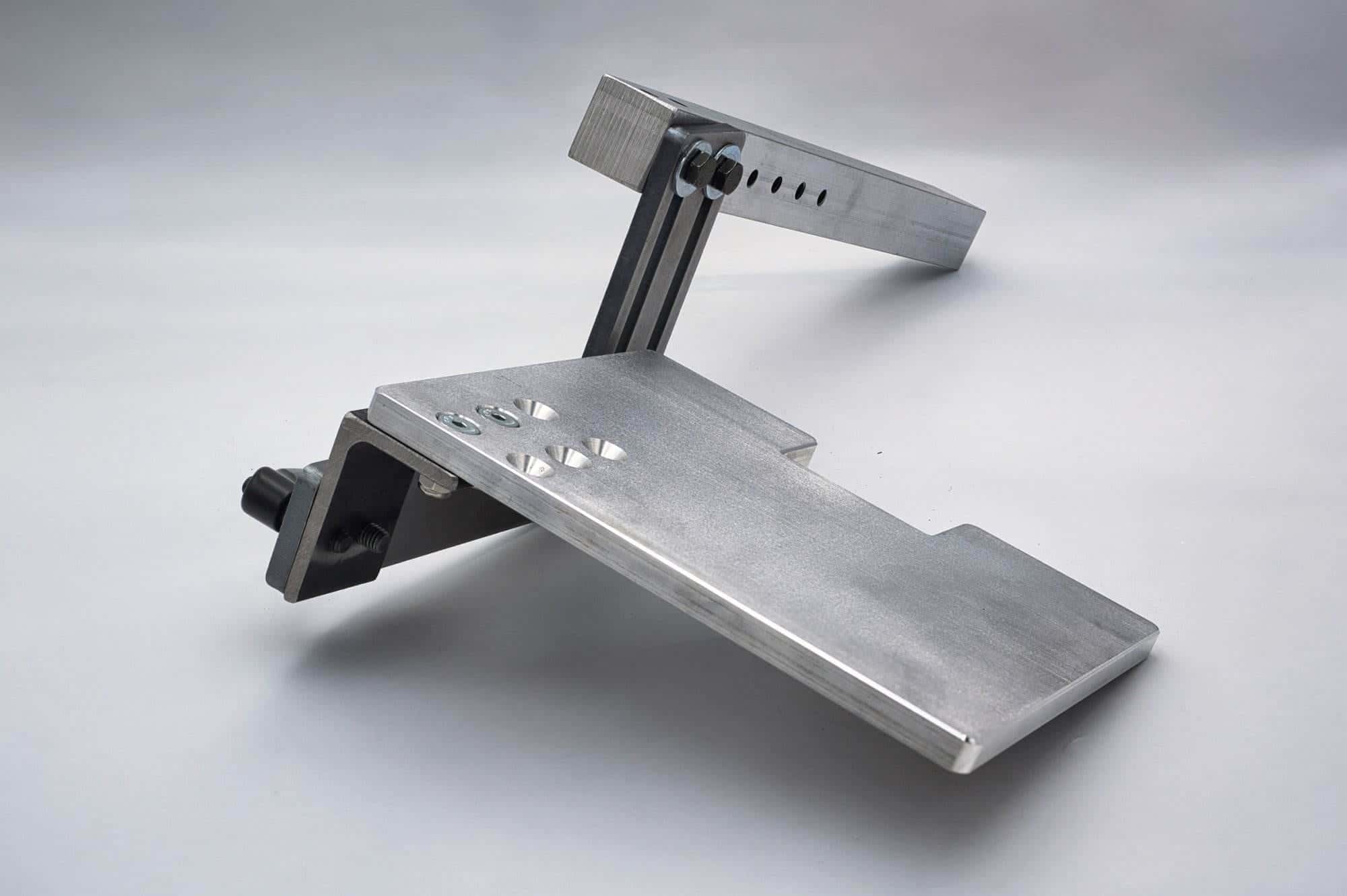 Reverse angle of an aluminum work rest plate showing the black adjustment knob and hinge bracket