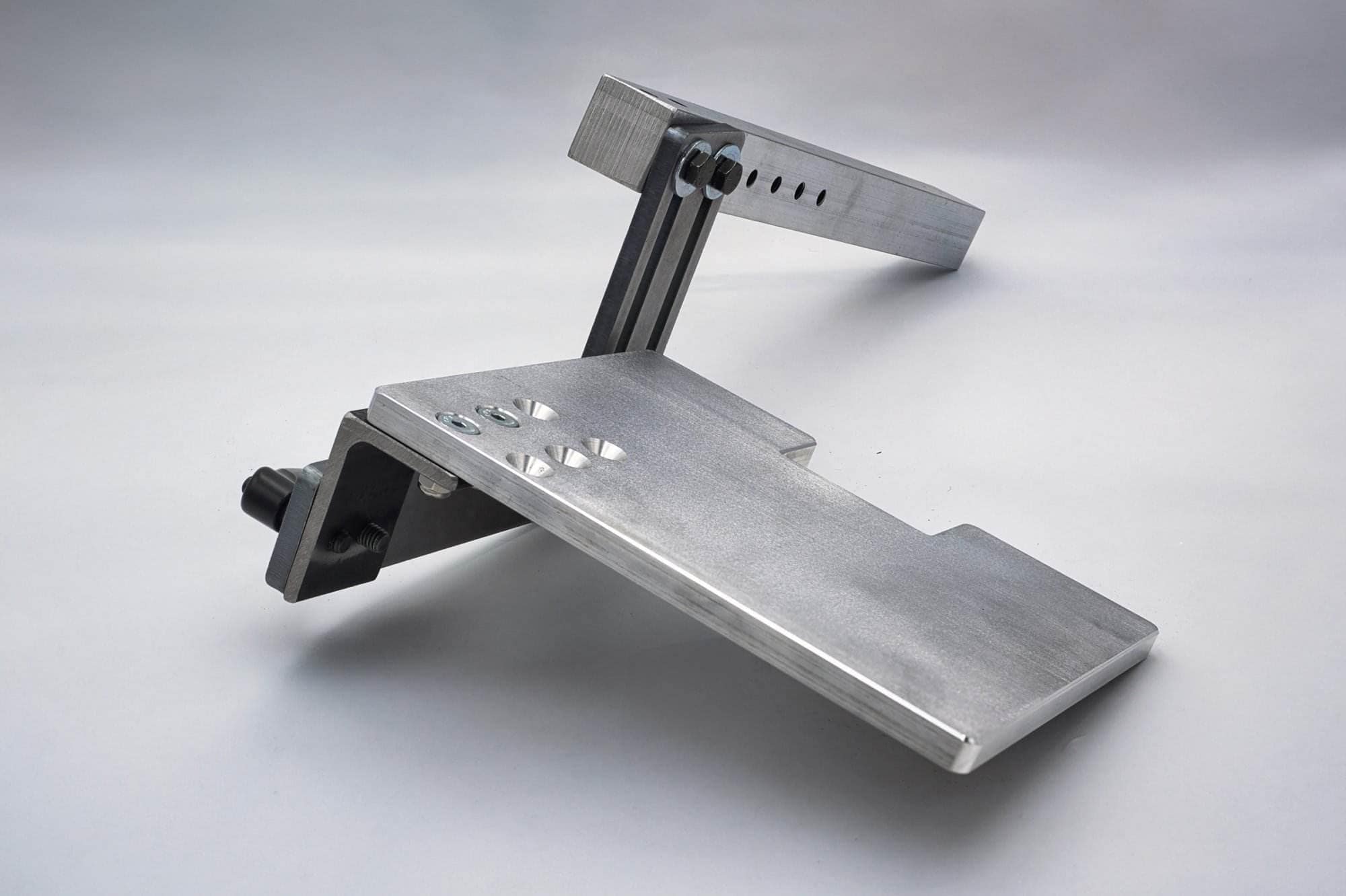 Reverse angle of an aluminum work rest plate showing the black adjustment knob and hinge bracket