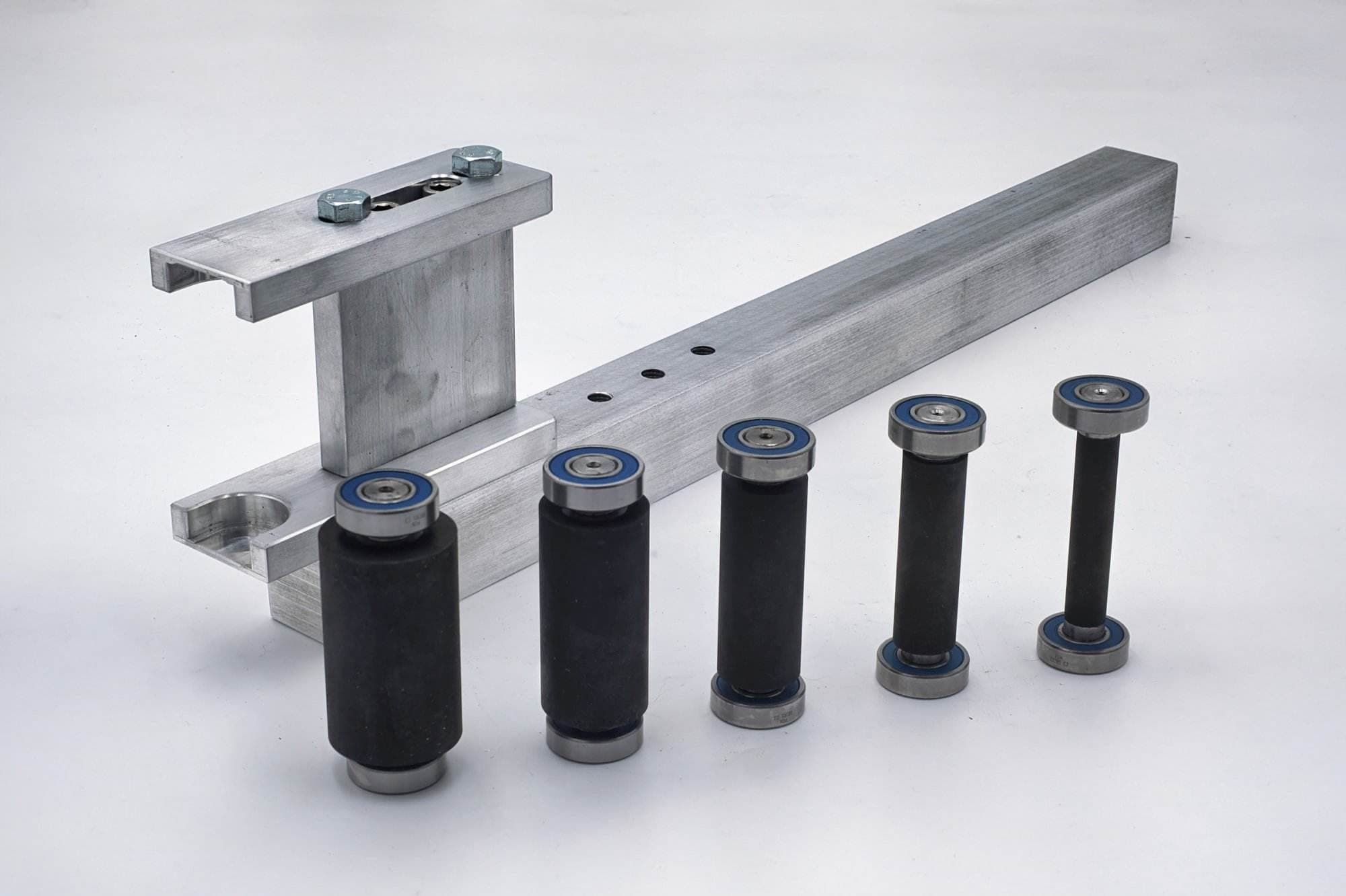 Steel work rest plate, notched clamp arm, and mounting bolts laid out before assembly