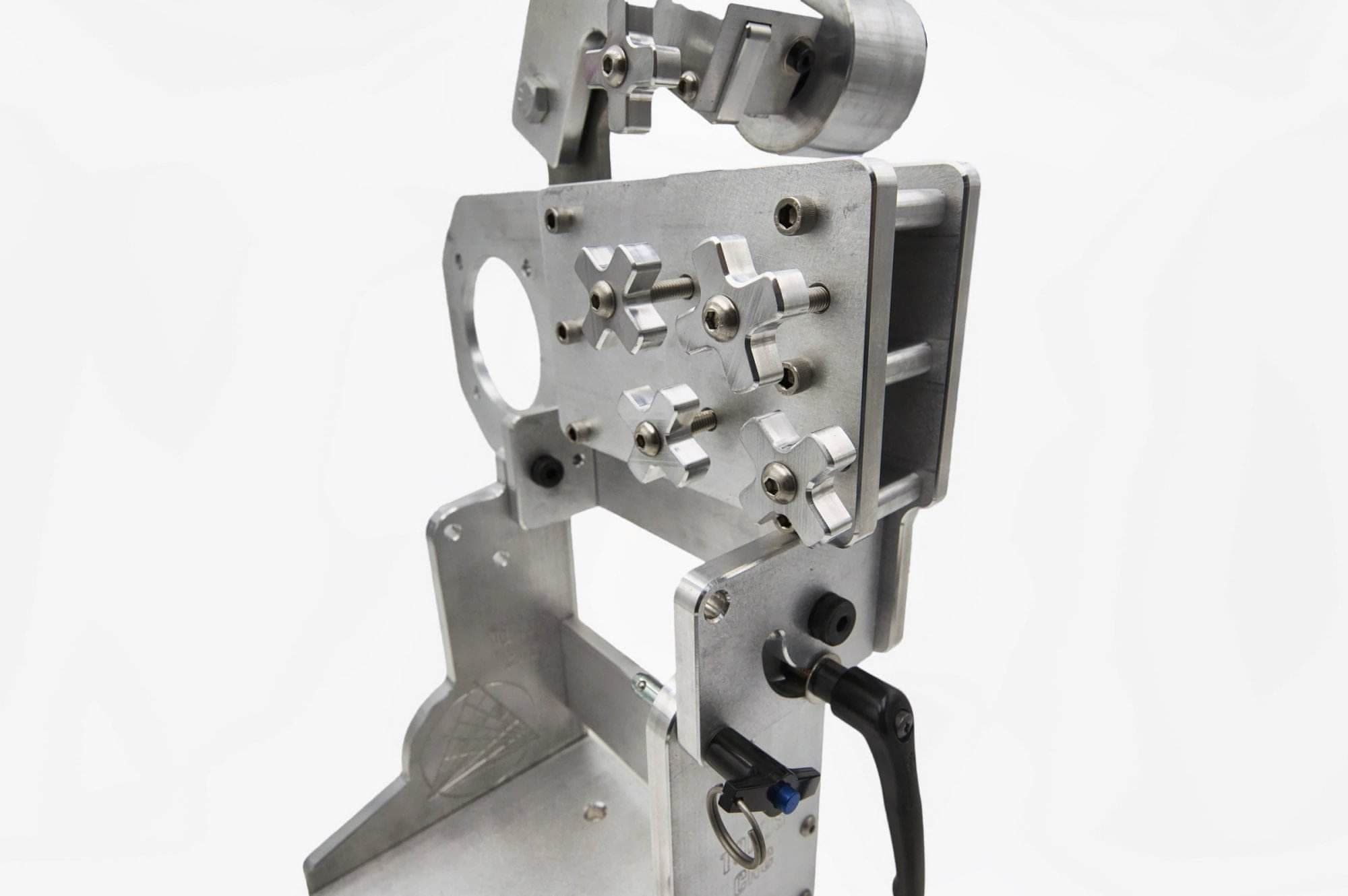Top-down view of a CNC aluminum tool arm mounting plate with cross-shaped adjustment knobs and idler wheel