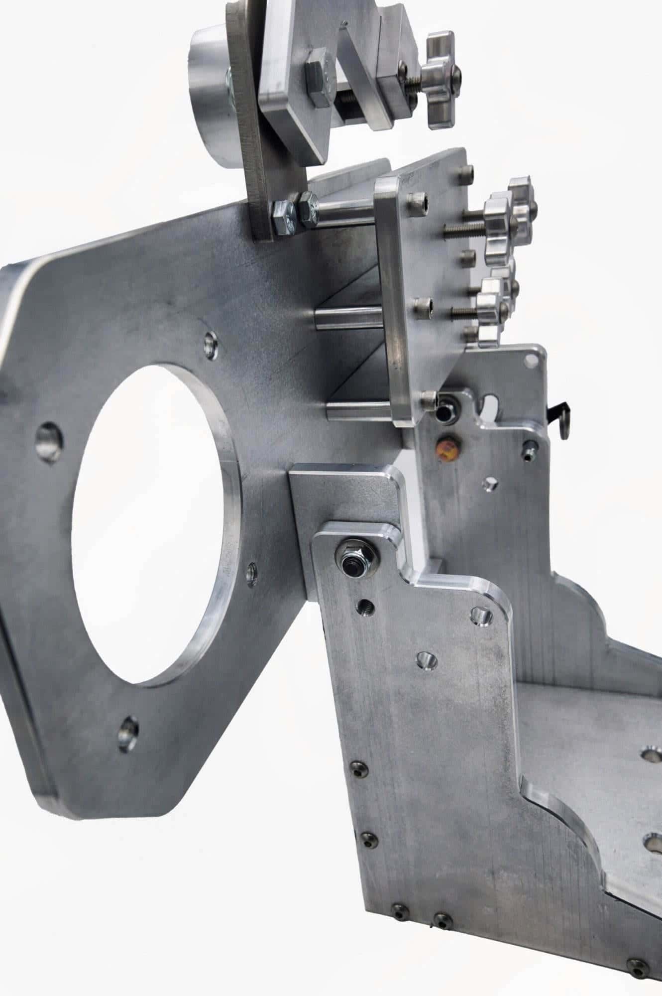 Angled view of a mounting plate's cross-knob adjusters and hook-style locking lever on an arm
