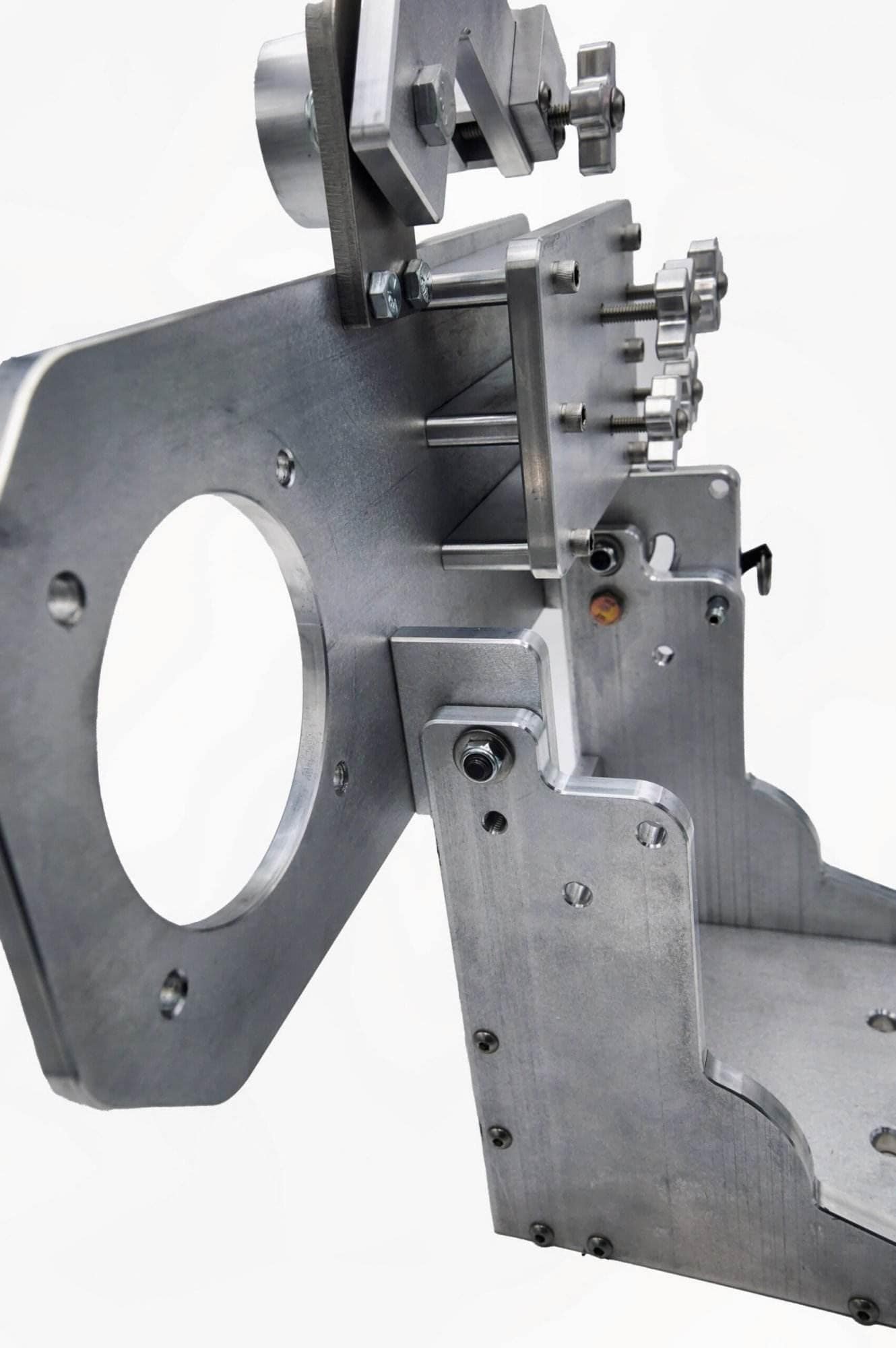 Angled view of a mounting plate's cross-knob adjusters and hook-style locking lever on an arm