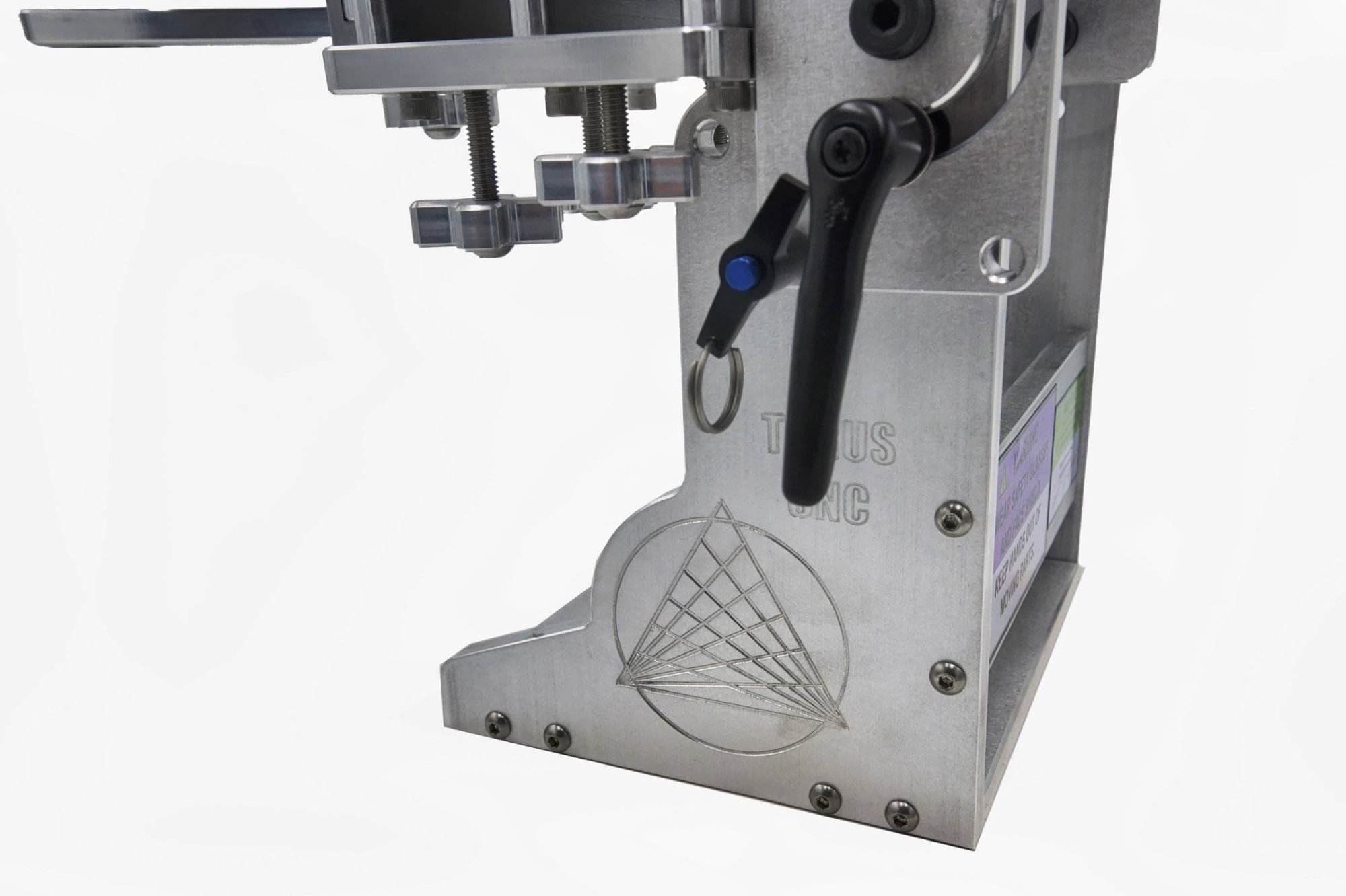 Close-up of a quick-release pin and locking lever on a Torus CNC grinder arm's engraved base