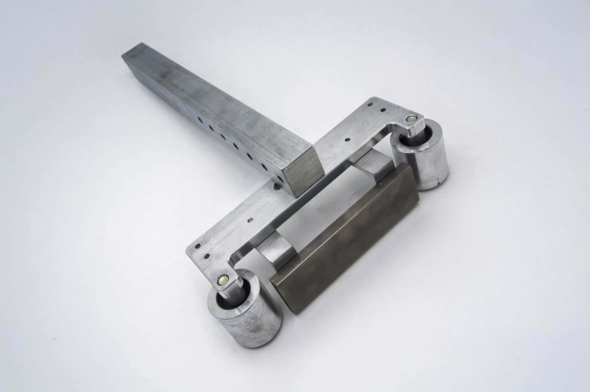 Aluminum pivot linkage arm with dual roller bearings for a 2x72 belt grinder tracking system