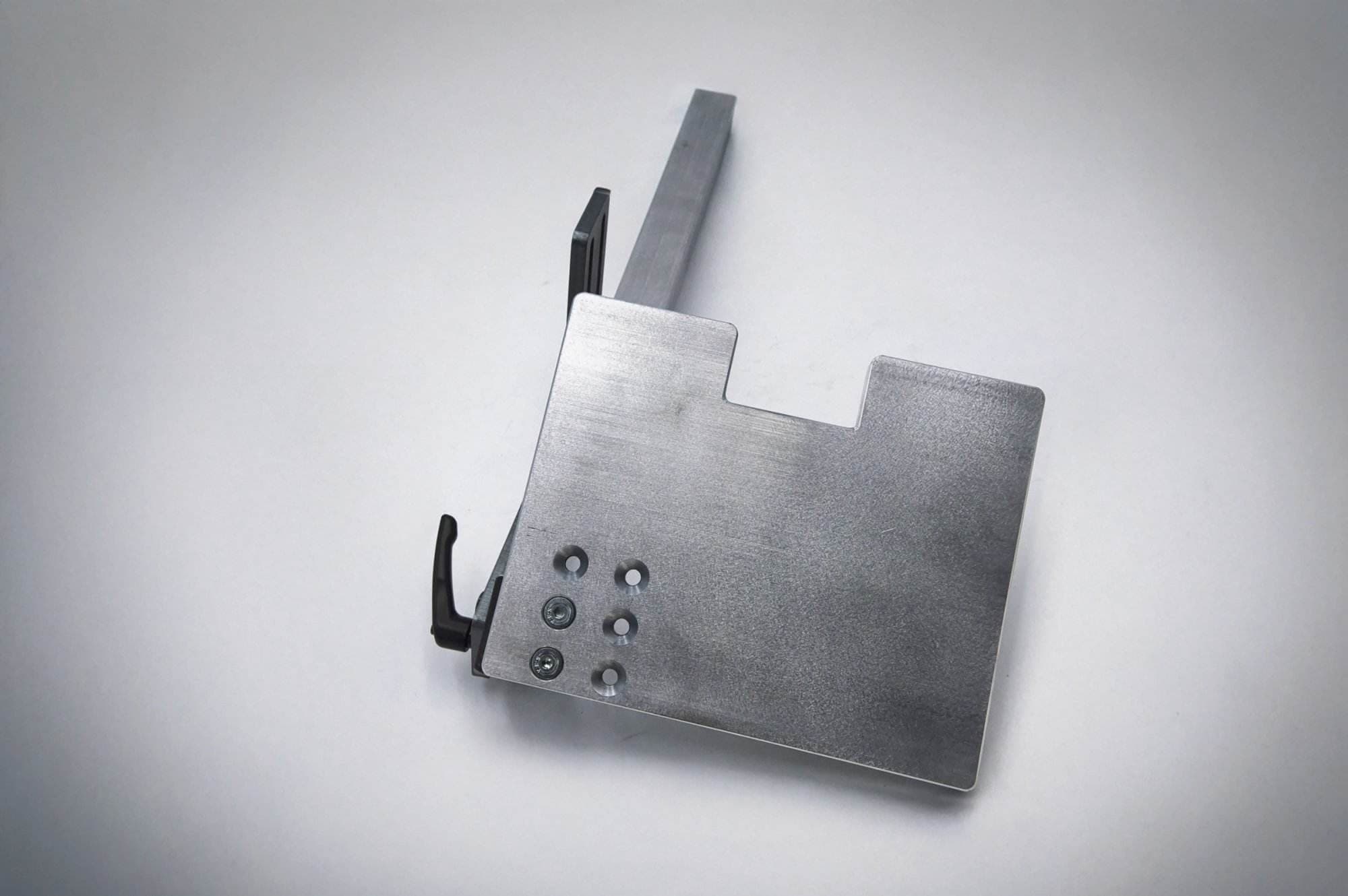 Machined quick-detach tool rest plate with countersunk mounting holes and adjustable arm