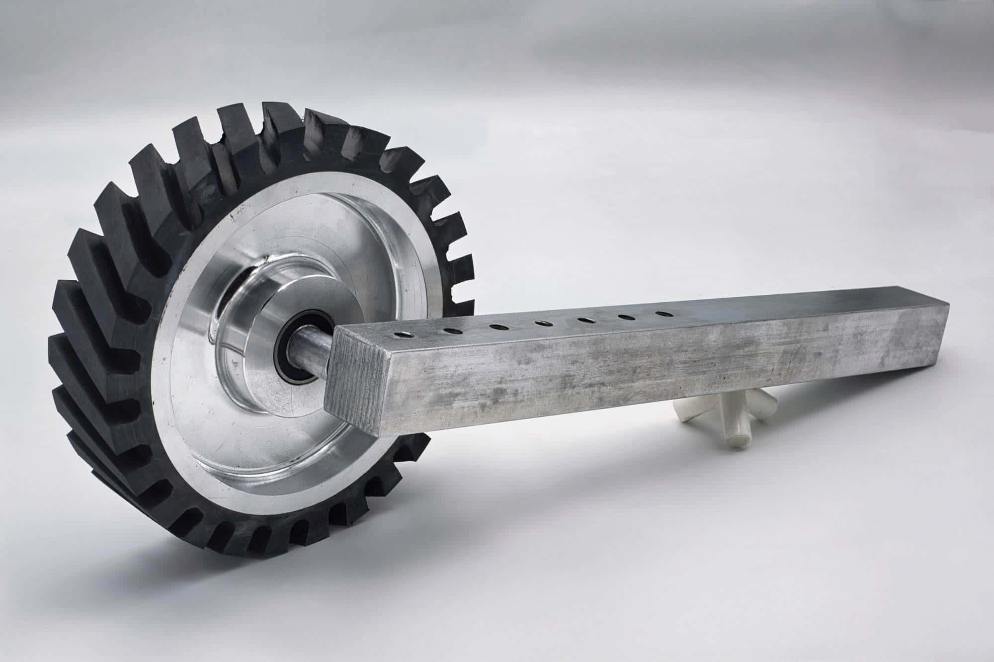 Toothed rubber contact wheel on a mill-stamped aluminum shaft with multiple mounting holes