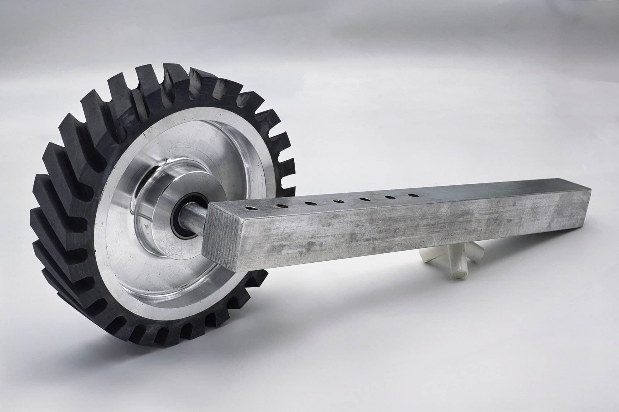 Toothed rubber contact wheel on a mill-stamped aluminum shaft with multiple mounting holes