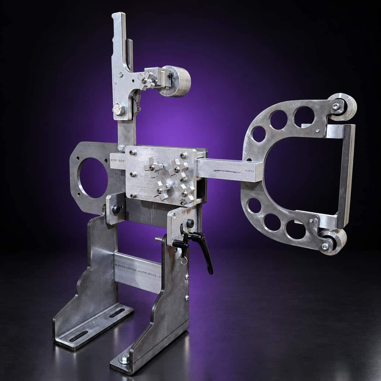 Torus steel 2x72 grinder, front three-quarter view: arm out to the right, star knobs, T-handle, on black with a purple glow
