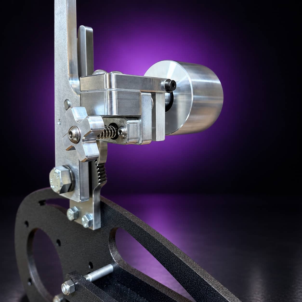 Nebula dual-axis tracking assembly: star knob, spring and idler wheel, close-up, on black with a purple glow