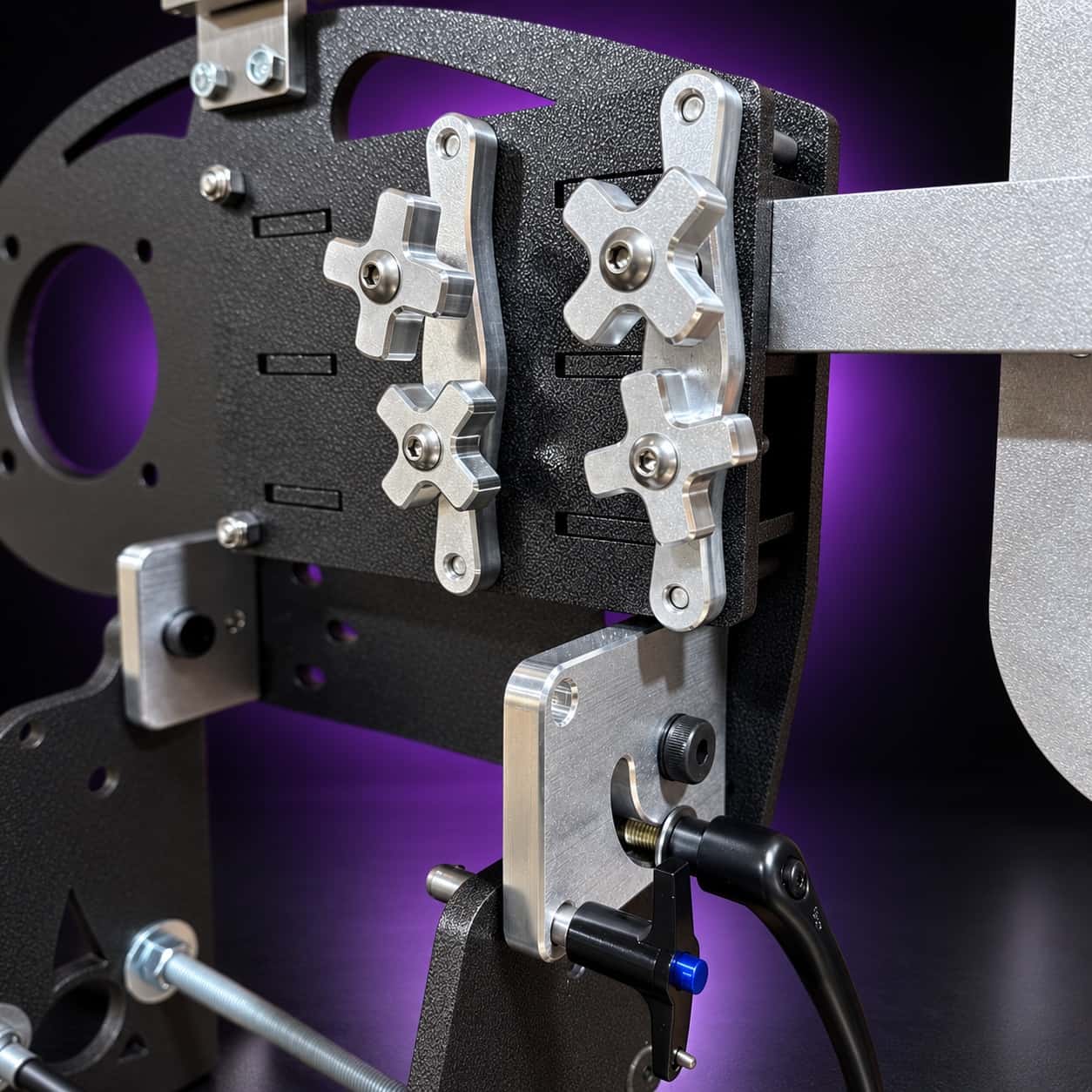 Nebula close-up: four star knobs on clamp plates, arm bar and black cam lever, on black with a purple glow