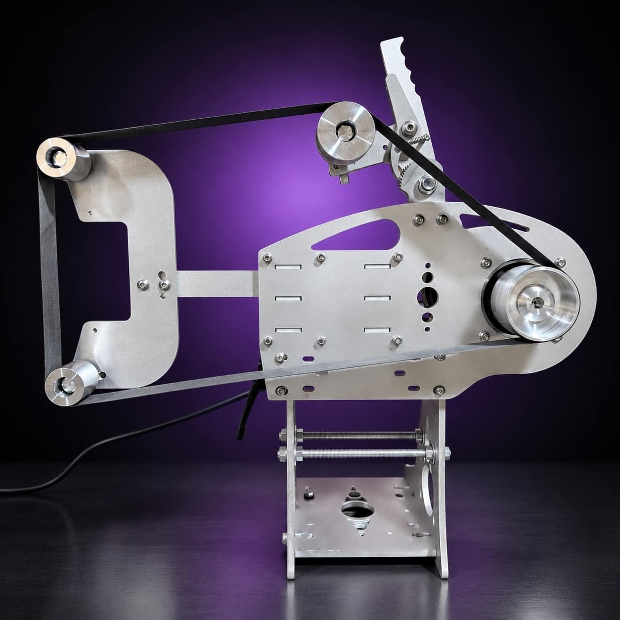 Nova aluminum 2x72 grinder with flat-platen tool arm and belt fitted, side view, on black with a purple glow