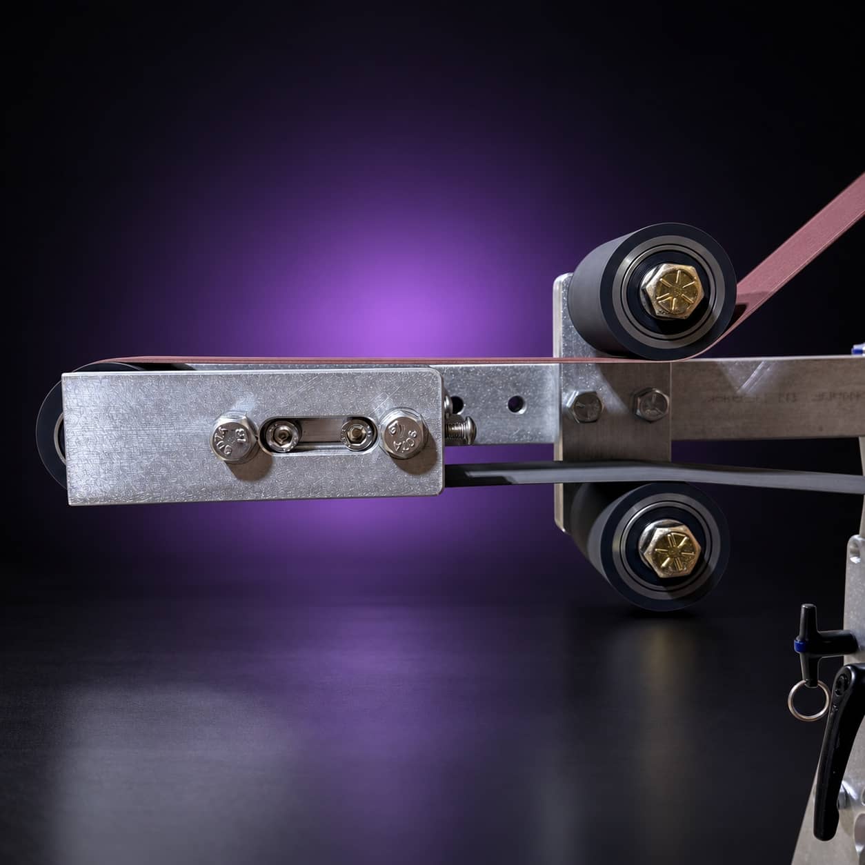 Small wheel attachment with the belt over the deflector wheels and small wheel, side view, on black with a purple glow